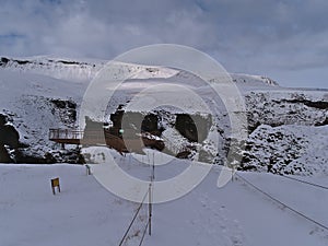 Snow-covered footpath and observation platform above famous canyon FjaÃ°rÃ¡rgljÃºfur in southern Iceland.