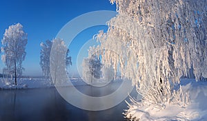 Snow-covered forest on the banks of the winter river, Russia, Ural
