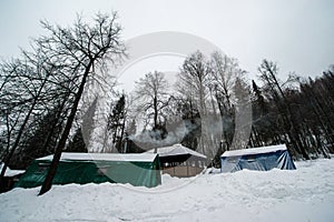 Snow-covered forest, Christmas trees in their white fur coats and a bath made of logs stands as if in a fairy tale