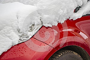 Snow-covered frozen car covered with snow. Winter road. Danger of winter driving. Car snow removal. Dangerous traffic situation