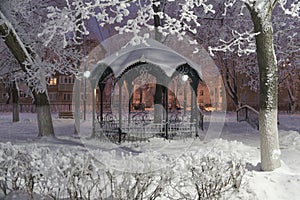 Snow-covered gazebo in the city Park on a winter night
