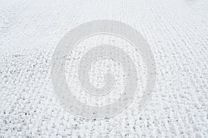 Snow-covered grid. The lattice fence is covered with fresh snow. Winter background texture. White background texture