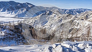 Snow-covered harsh mountain range against the blue sky.