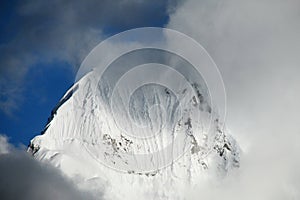 Snow covered high mountain in a dark cloud