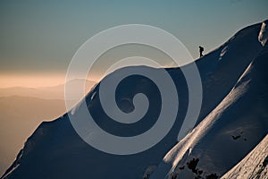 snow-covered hill with powdery snow and a man skier on it. Ski touring and freeride concept