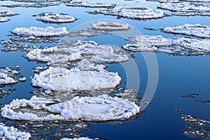 Snow-covered ice floes float along a river Neman