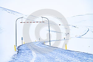 Snow covered Icelandic road snaking up to a mountain pass