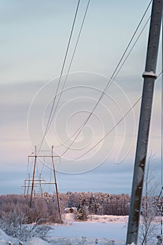 Snow-Covered Landscape With Power Lines and Electricity Poles at Dusk