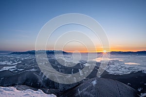 Zasnežená krajina východ slnka z Veľkého Choča v zime, s výhľadom na Nízke a Vysoké Tatry a Liptovskú Maru,