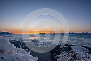 Snow covered landscape sunrise sun from Velky Choc mountain in winter, with view of low and high Tatras and Liptovska Mara,