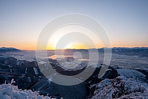 Snow covered landscape sunrise from Velky Choc mountain in winter, with view of low and high Tatras and Liptovska Mara, slovakia