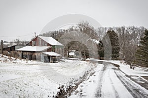 Snow covered lane leading to a weathered barn