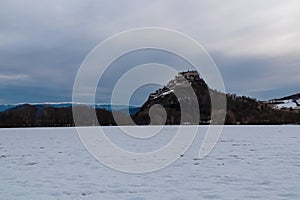 Snow covered meadow with panoramic view of medieval castle Burg Hochosterwitz build on hill in Sankt Georgen am LŠngsee