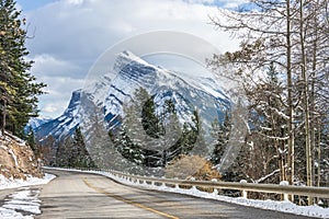 Snow-covered Mount Rundle with snowy forest mountain road. Mount Norquay Scenic Drive. Banff National Park