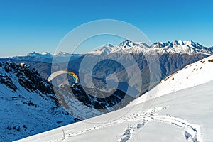 Snow covered mountain with flighting skydiver