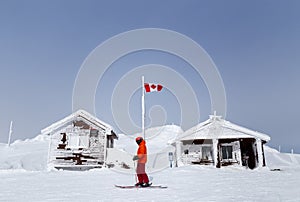 Snow covered mountain hut with a Canadian flag on Whistler Mountain, BC.