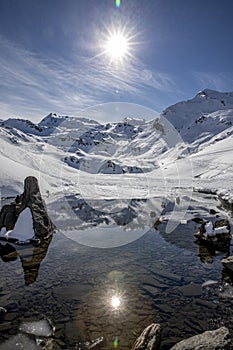 The snow-covered mountain and its reflection in Lac du Lou near Val Thorens resort