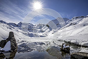 The snow-covered mountain and its reflection in Lac du Lou near Val Thorens resort