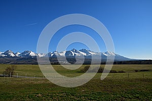 Zasněžené horské štíty s travnatou krajinou na jaře Vysoké Tatry Slovensko