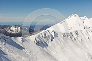 Snow-covered mountain range against the background of the sea