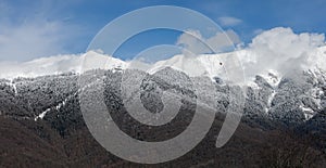 Snow-covered mountain range on the background of lower mountains