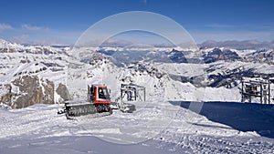 Snow-Covered Mountain Range with Red Snowcat in Foreground photo