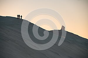 snow-covered mountain slope along the top of which a group of skiers is walking. Ski touring concept