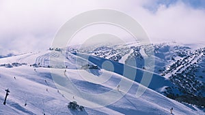 Snow-covered mountain slope with a stunning view of snow-dusted hills in the background.