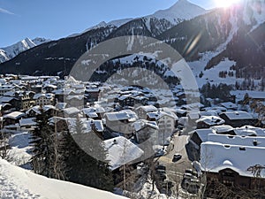 Snow covered mountain village of munster inf valais, the first rays of sunshine are shining over the mountains