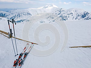 Snow covered mountains and alpine skis on a foreground