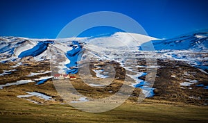 Snow covered mountains and Countyside with red roofed farmhouse in Iceland photo