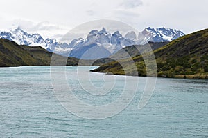 Snow covered mountains with the light blue ocean in front in Torres del Paine National Park in Chile, Patagonia