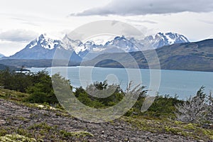 Snow covered mountains with the light blue ocean in front in Torres del Paine National Park in Chile, Patagonia