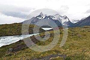 Snow covered mountains with the light blue ocean in front in Torres del Paine National Park in Chile, Patagonia