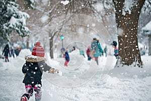 snow-covered park, where children are engaged in a spirited snowball fight
