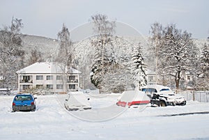 Snow covered parking lot, cars under