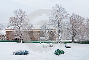 Snow covered parking lot, cars under