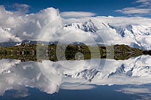 Snow-covered mountain range mirroring in a lake