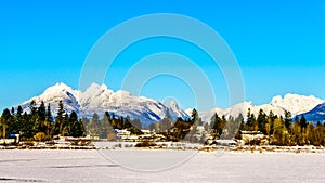 The snow covered peaks of the Golden Ears Mountain and Mount Robie Reid behind the town of Fort Langley in the Fraser Valley