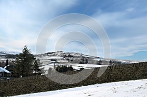 Snow covered pennine landscape with a view of fields and houses in heptonstall in calderdale west yorkshire surrounded by a stone