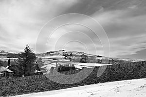 Snow covered pennine landscape with a view of fields and houses in heptonstall in calderdale west yorkshire surrounded by a stone