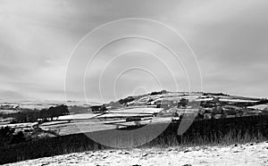 Snow covered pennine landscape with a view of fields and houses in heptonstall in calderdale west yorkshire surrounded by a stone