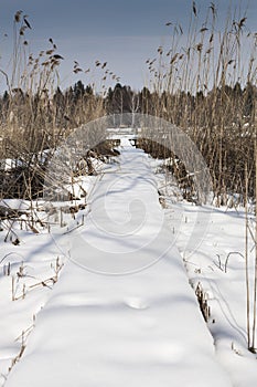 Snow covered pier near a lake, wintertime in Diosjeno