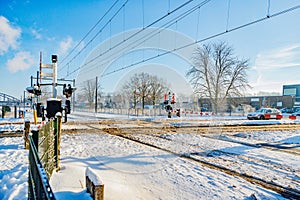 Snow covered railway crossing on road in winter landscape