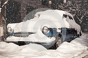 Snow-covered retro car. Vintage effect