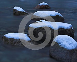 Snow covered river rocks
