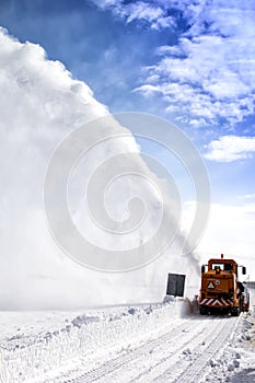 Snow-covered road cleaning by snow removal machine.