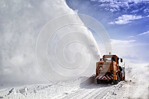 Snow-covered road cleaning by snow removal machine.