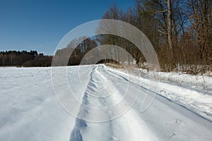 Snow-covered country road at the forest