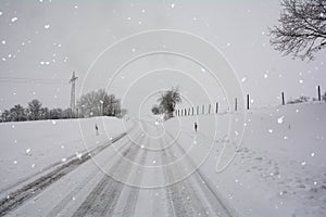 Snow-covered road in winter with snowfall